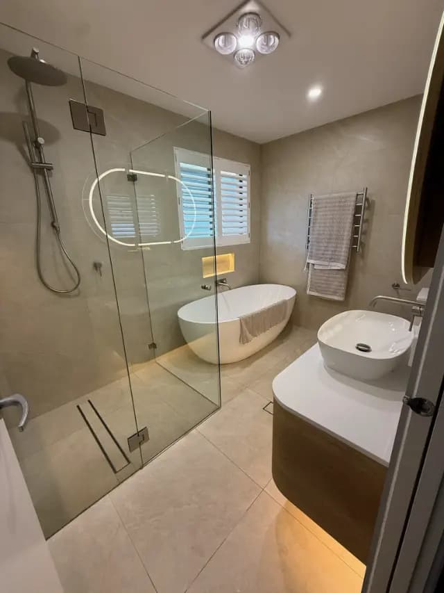 Completed bathroom with frameless shower and freestanding bath